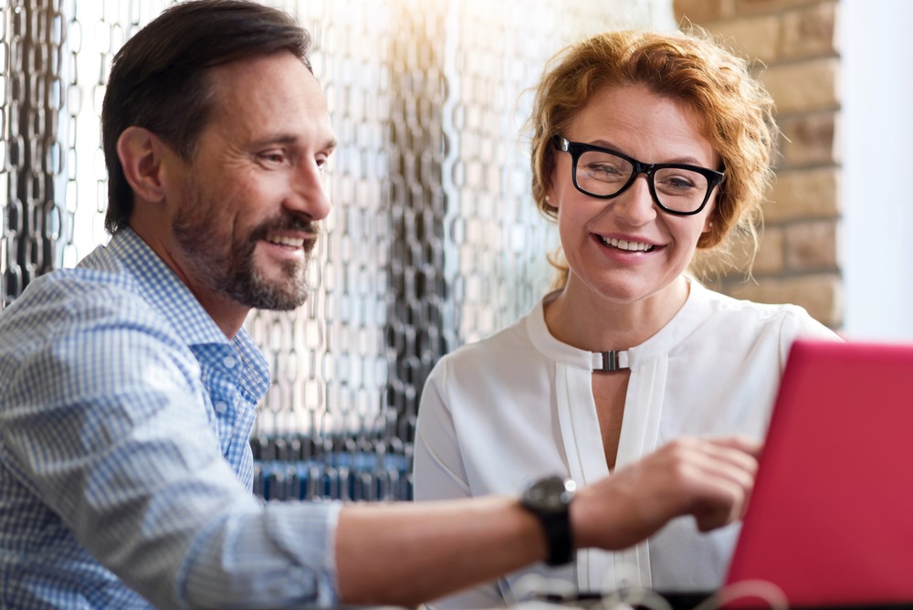 Middle-aged,Man,And,Woman,Discussing,Information,From,Laptop